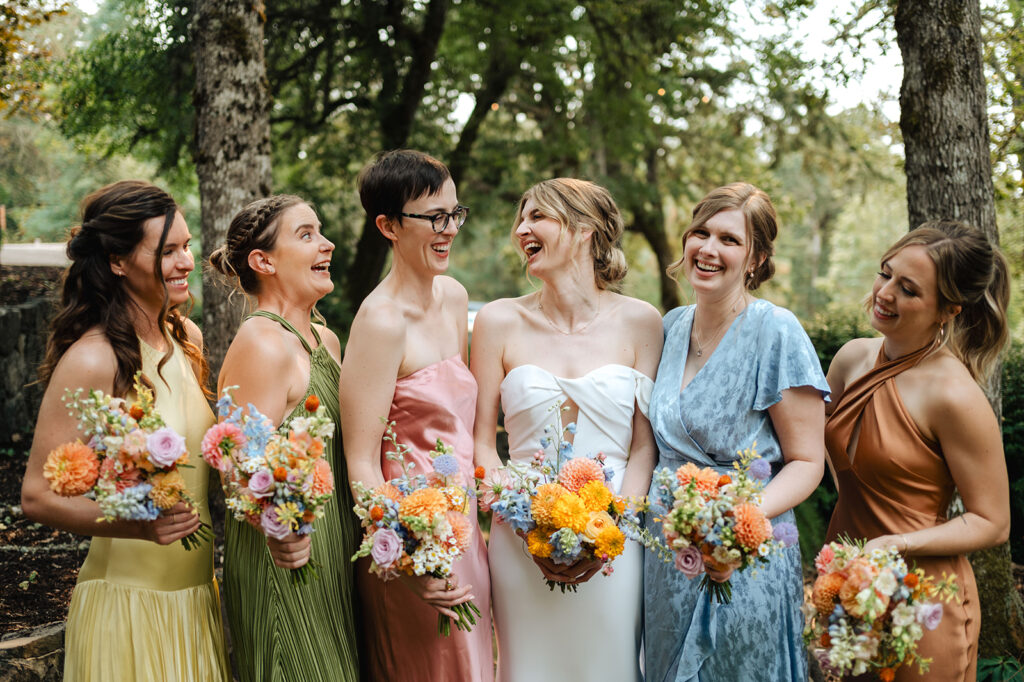 bride and bridesmaids in colorful dresses at wedding 