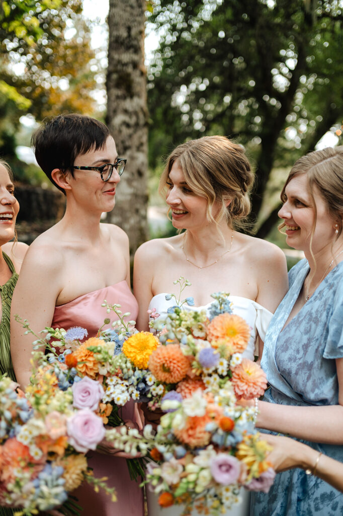 bride and bridesmaids in colorful dresses at wedding 