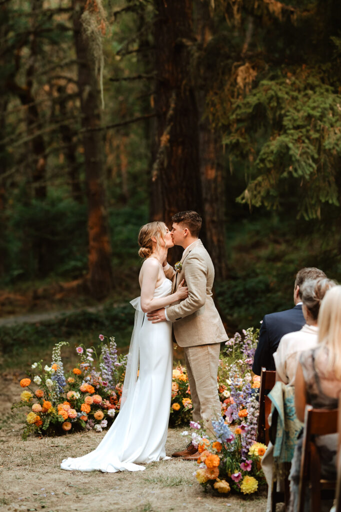 bride and groom first kiss at wedding ceremony at oregon forest wedding at mount Tom House